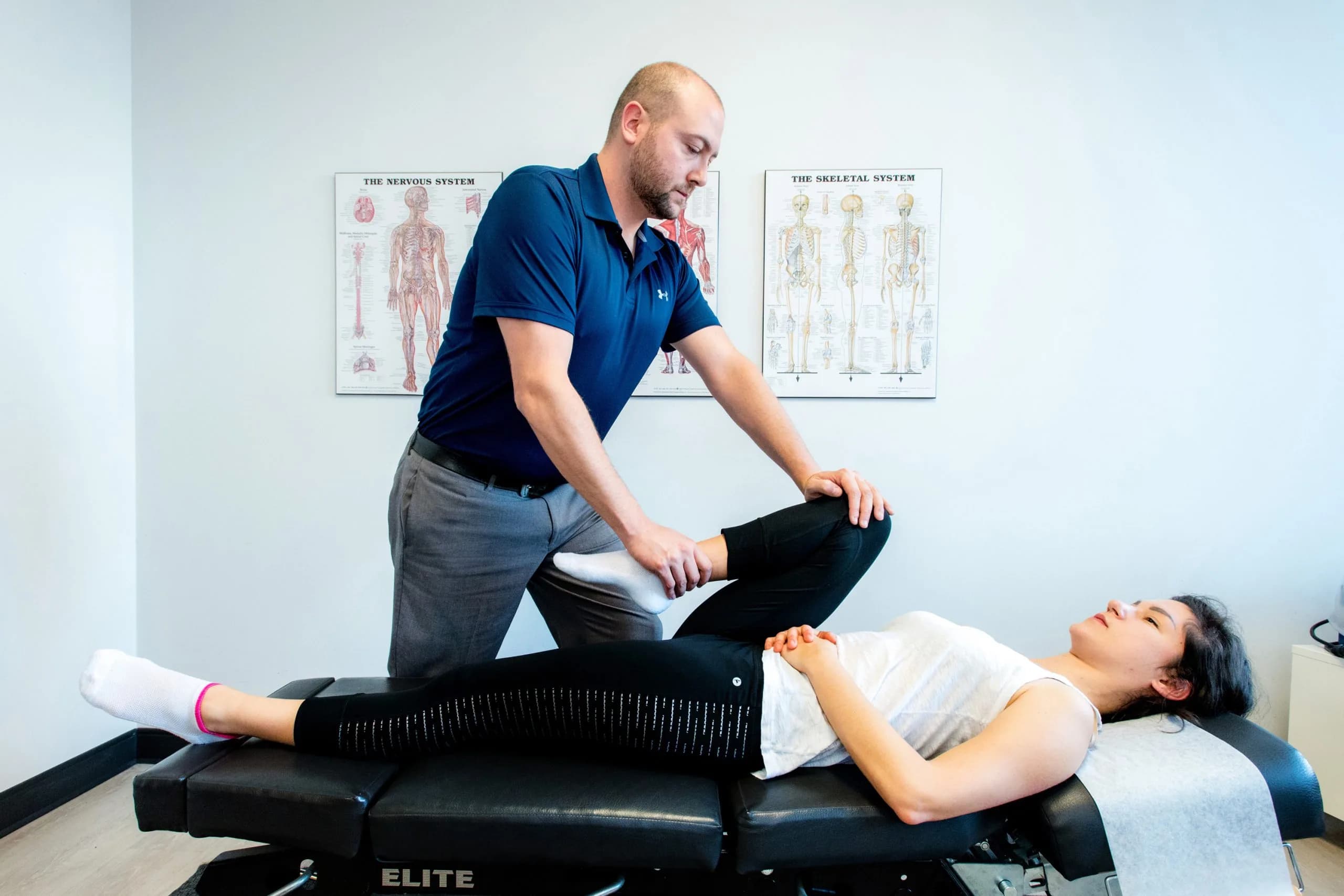 Chiropractor performing an orthopedic spine and hip assessment on the treatment table