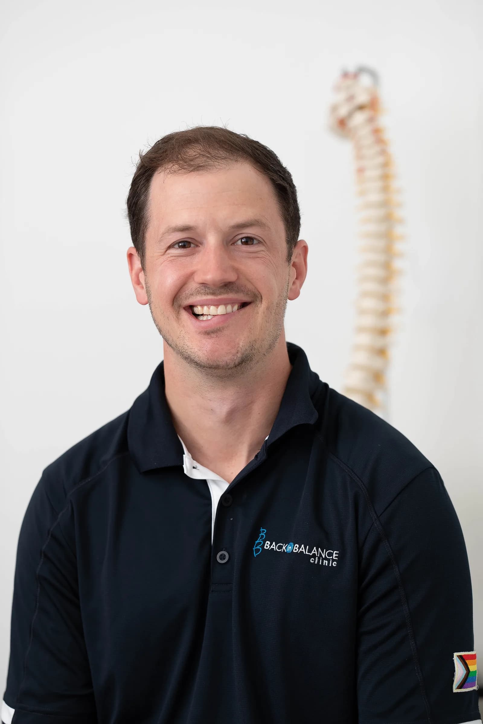 Headshot of Dr. Steven Murray with a spine in the background